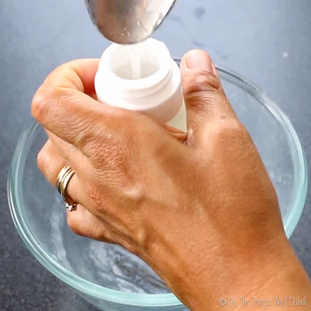 pouring a homemade hair gel into a silicone travel tube