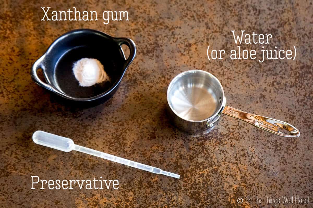 Overhead view of xanthan gum and water next to a pipette with a cosmetic preservative