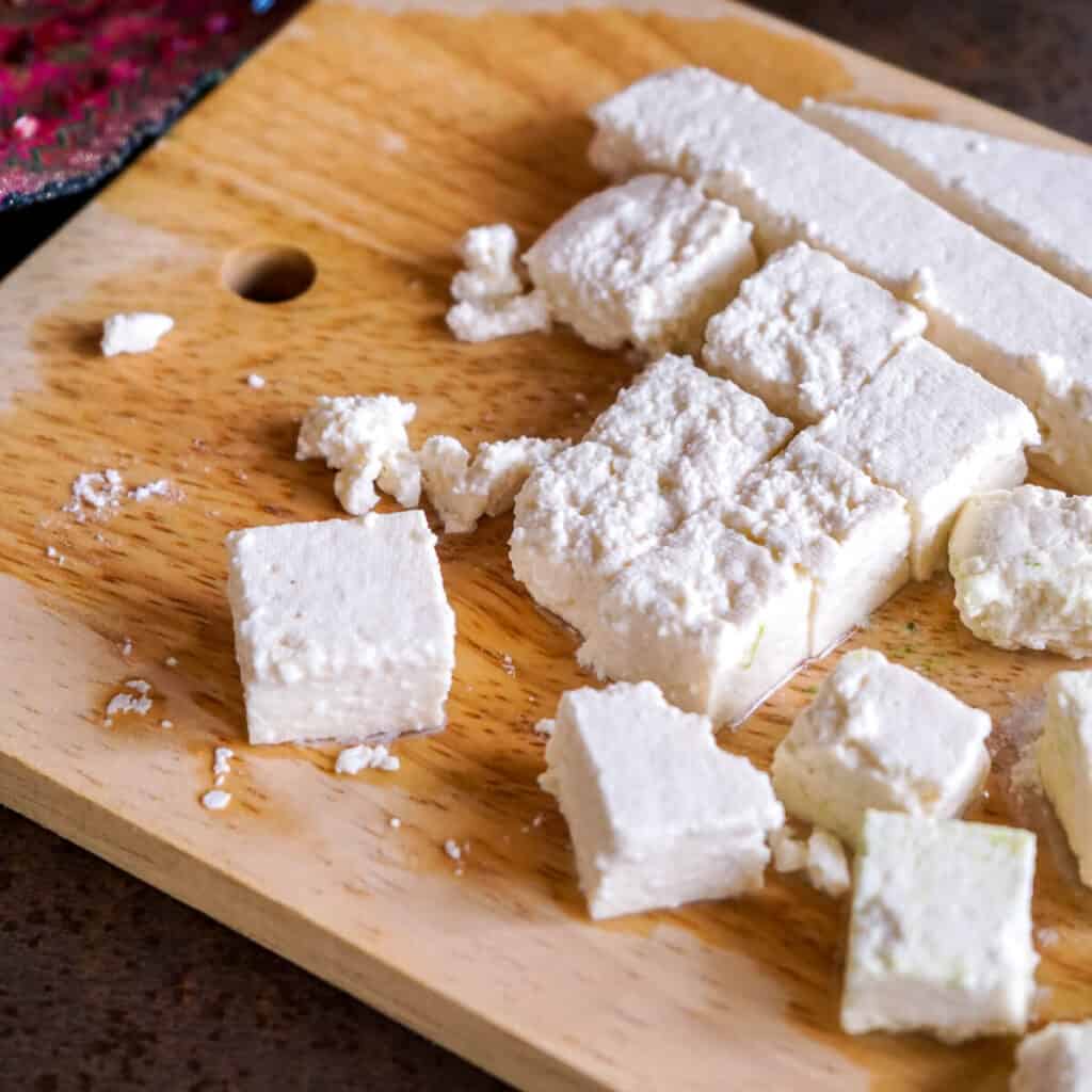 Close-up of cut up paneer, soft Indian cheese.