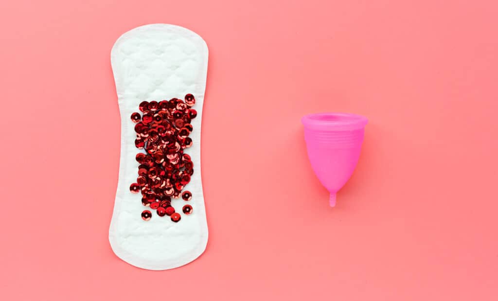 A menstrual cup next to a pad