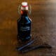 A bottle of alcohol free vanilla extract with some vanilla beans