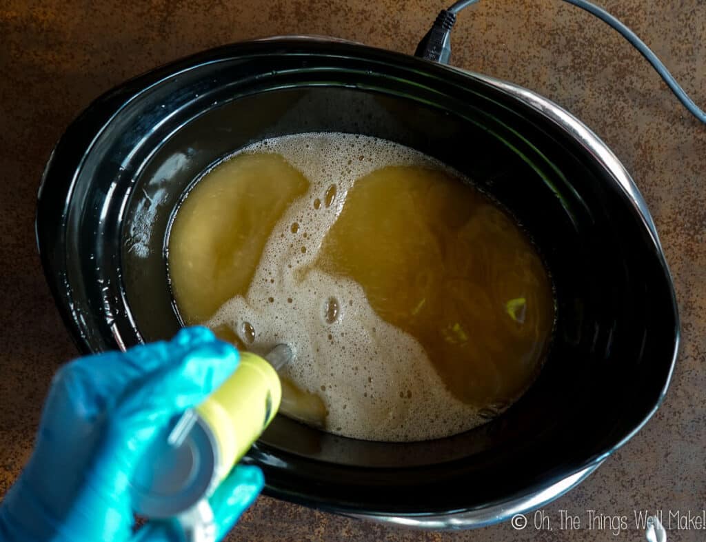 using an immersion blender to blend the oil with the lye solution