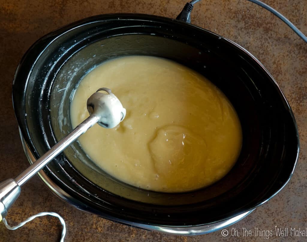 Overhead view of a creamy pudding-like soap mixture in a slow cooker