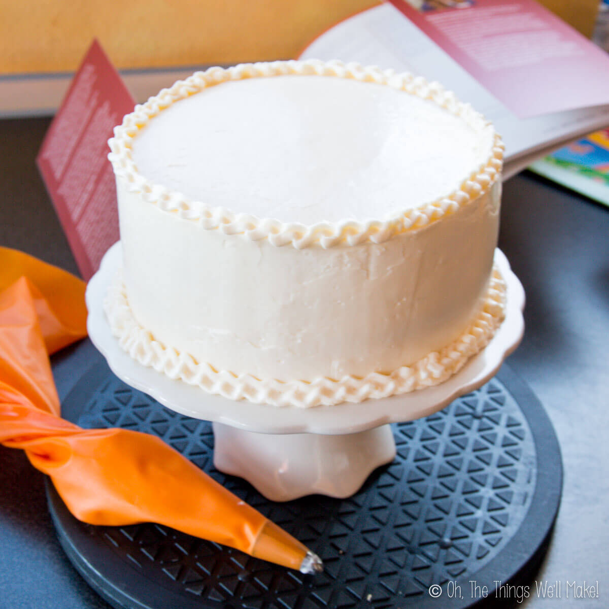 A cake with Swiss buttercream frosting on a cake stand.
