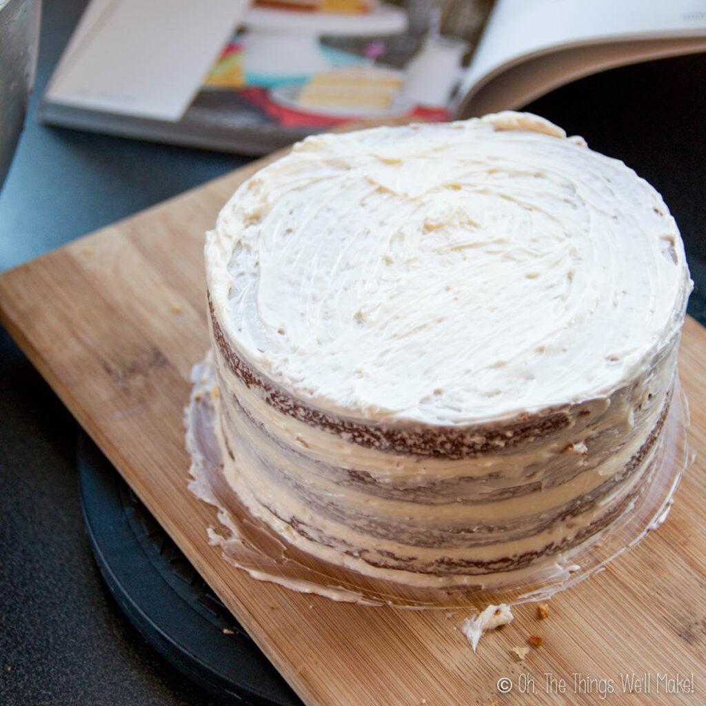 A cake with a thin crumb coat layer of frosting