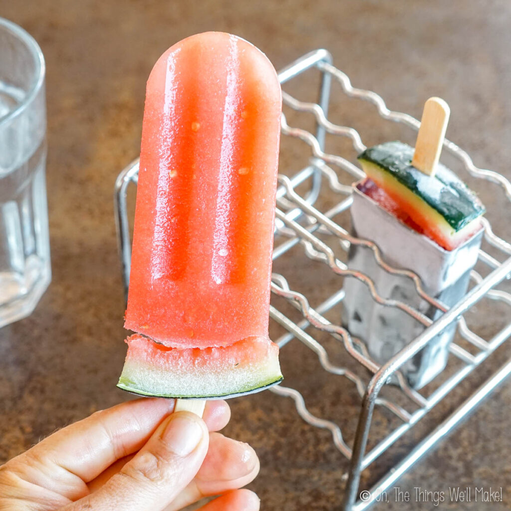 A popsicle with the watermelon rind separated from the rest of the popsicle with a gap