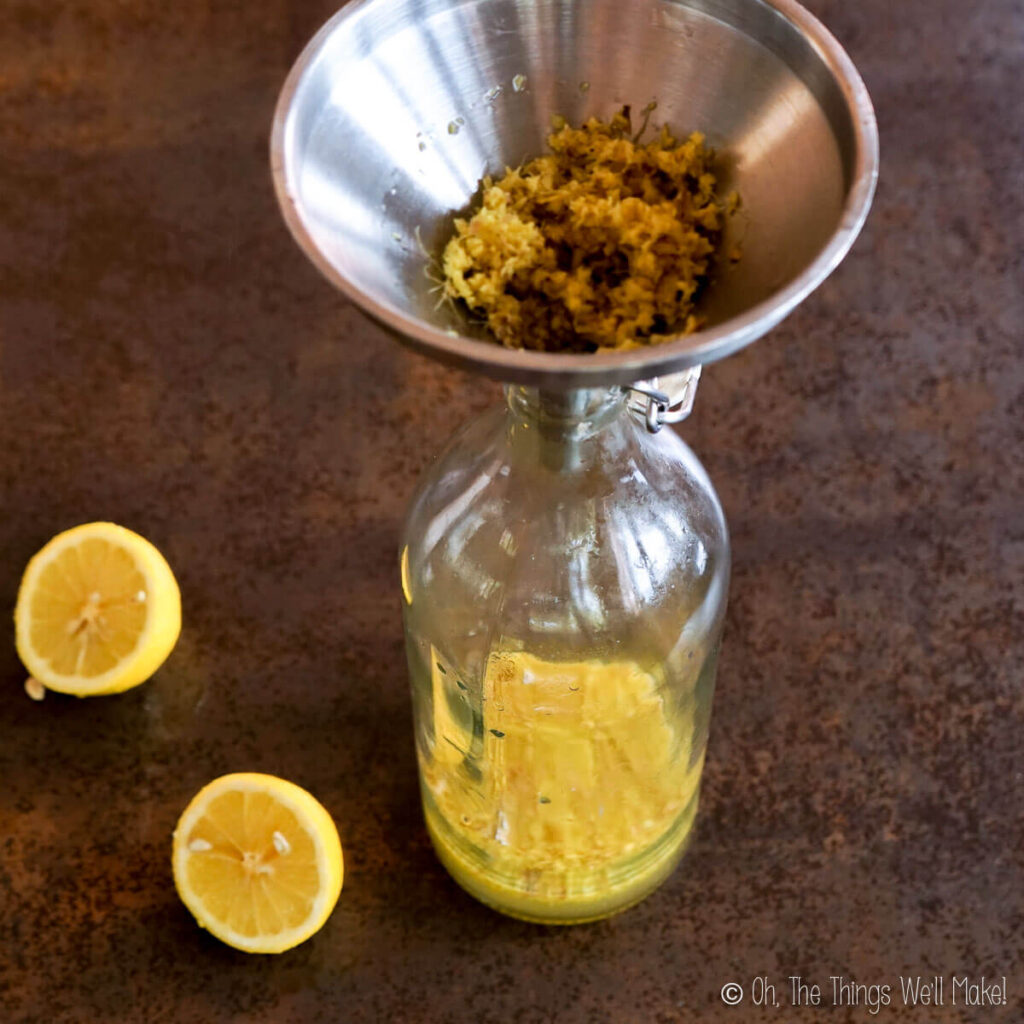 Adding minced ginger to a funnel over a bottle