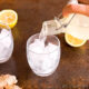pouring ginger beer into a glass with ice