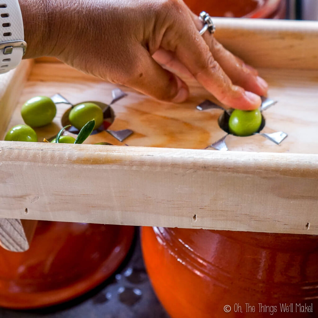pressing an olive through an olive slitter
