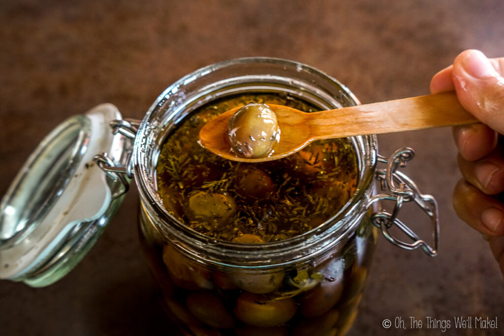 Removing an olive from a jar using a wooden spoon