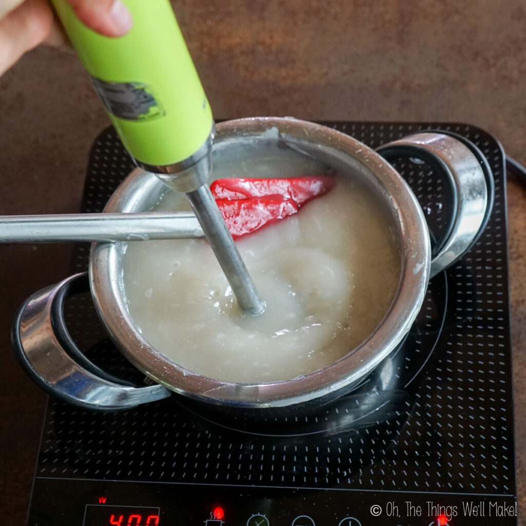 Blending a thick starch mixture in a pan with an immersion blender