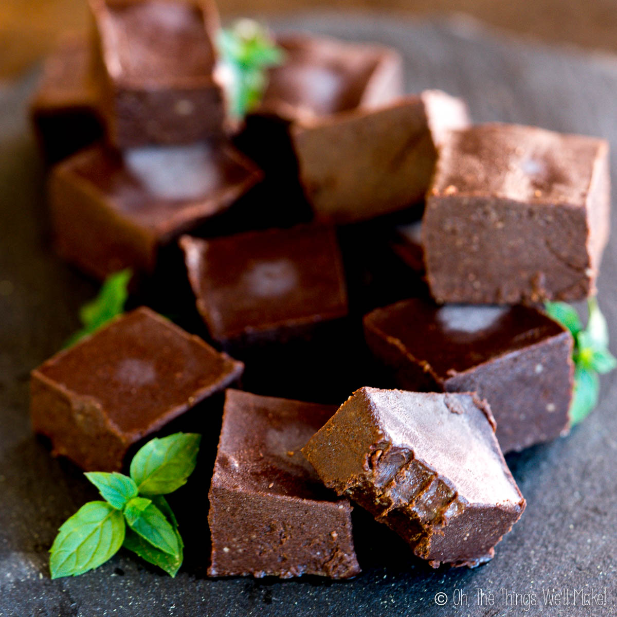 Several pieces of mint chocolate fudge garnished with mint sprigs