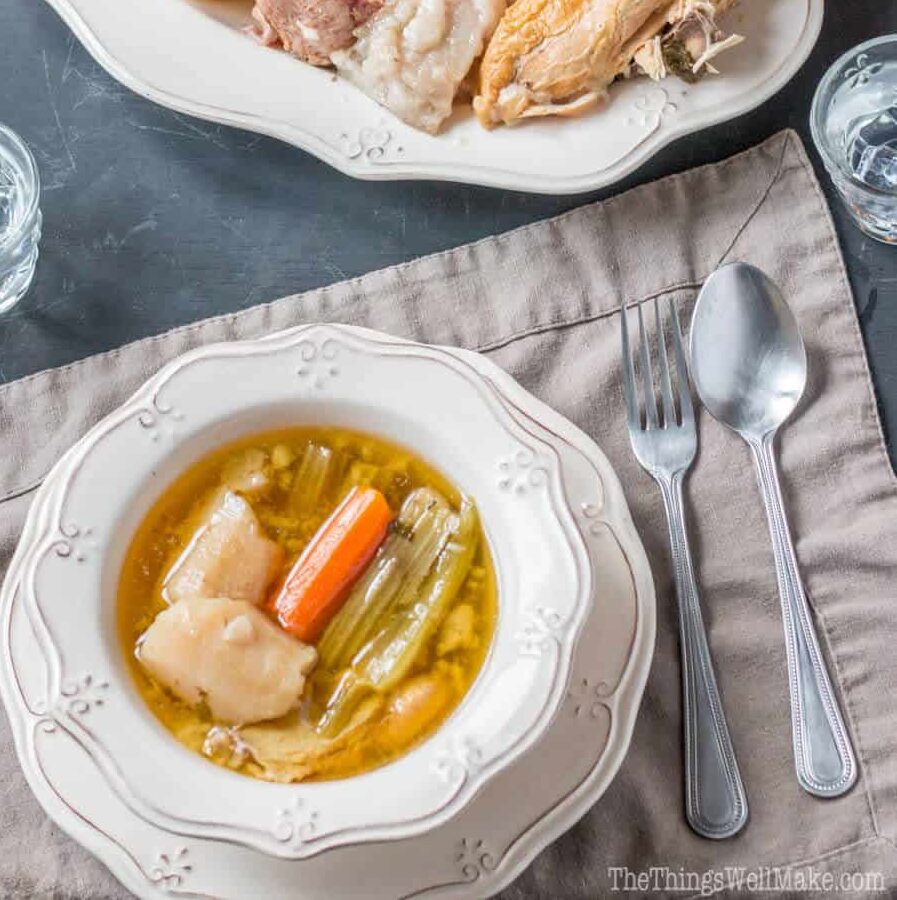 Overhead view of a plate of Valencian puchero and a bowl with broth and veggies