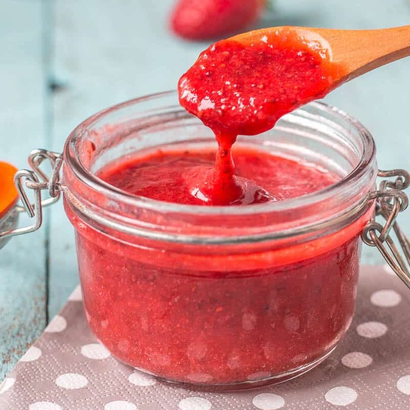 scooping up strawberry chia seed jam and letting it fall fromt he spoon to show the texture