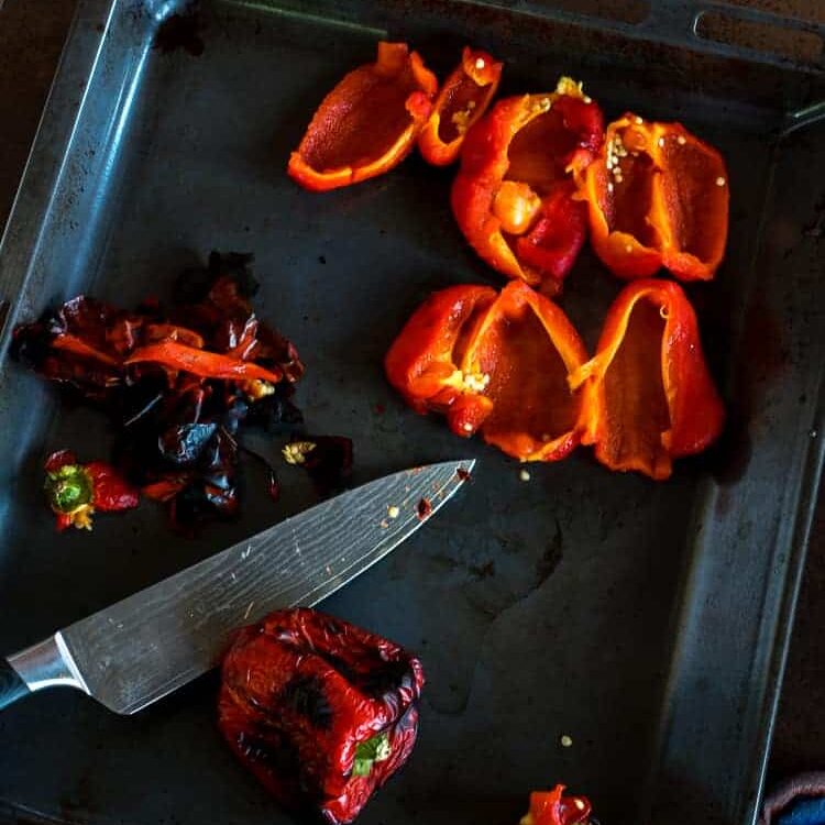 Removing the skin and seeds from roasted red peppers.
