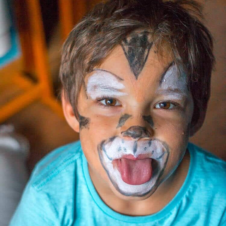 Boy wearing homemade costume makeup painted to look like a tiger