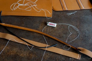 sewing up a strap for a leather purse