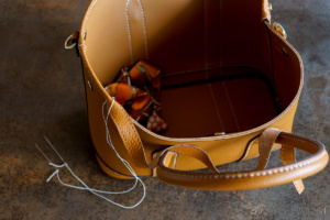 Sewing a leather strip around the top of a leather purse
