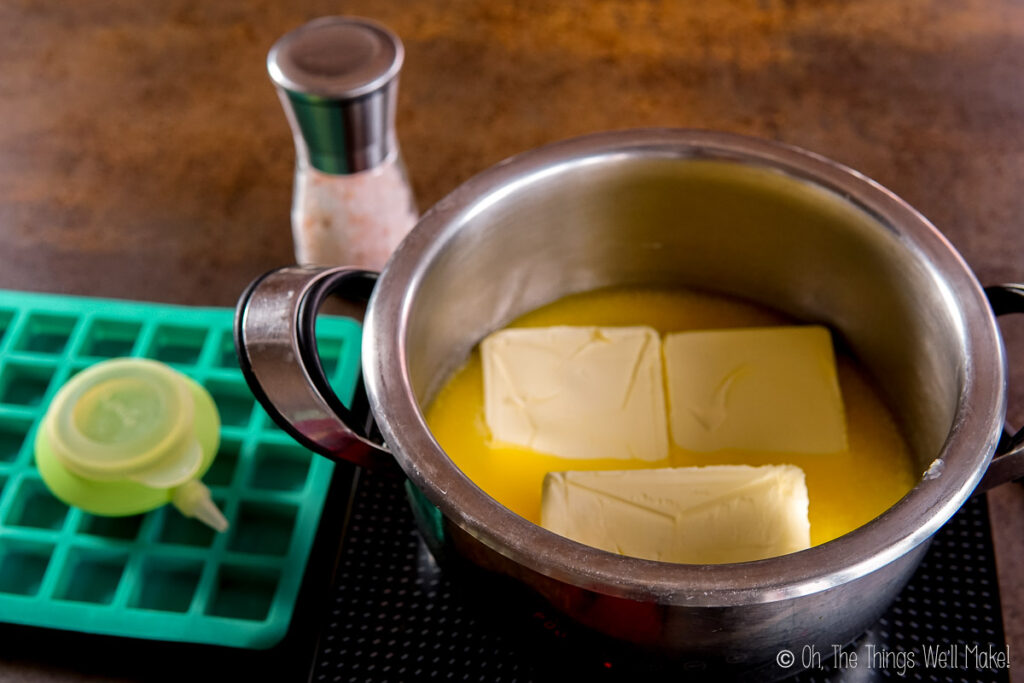 butter blocks melting in a stainless steel pan