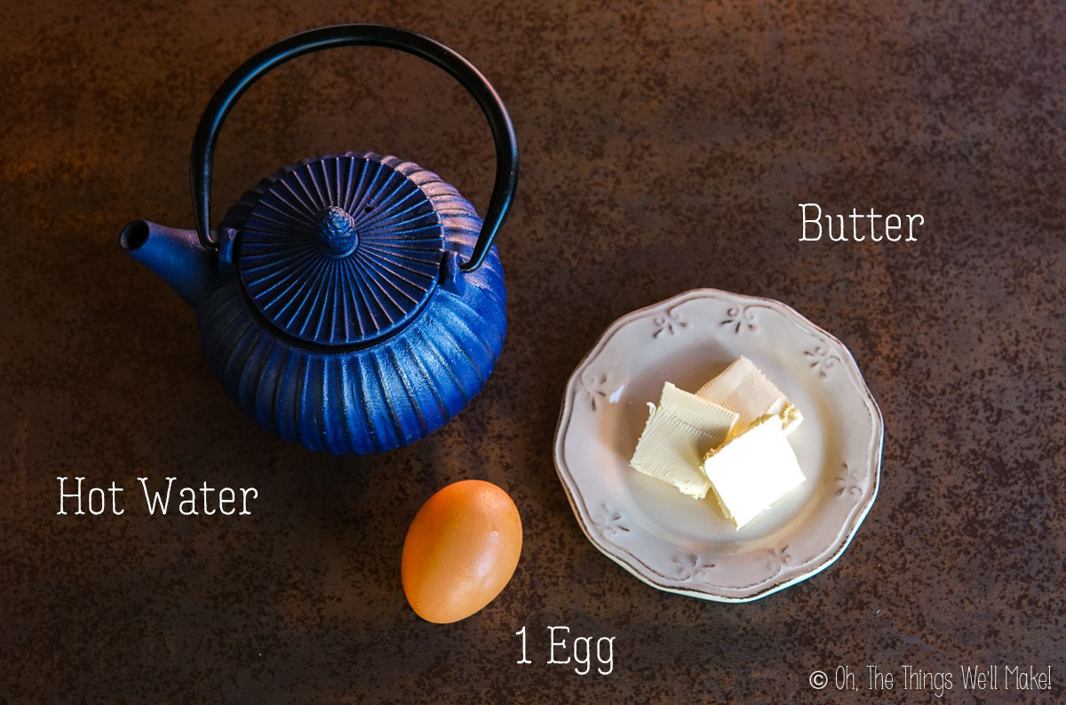overhead view of hot water, butter, and an egg