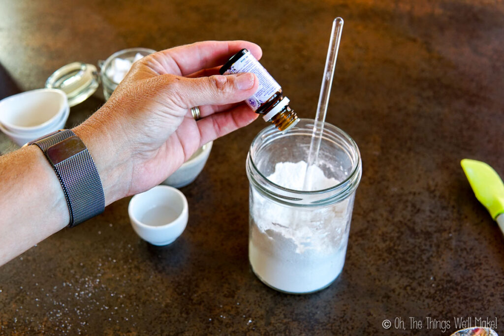 Adding essential oils to a glass jar.