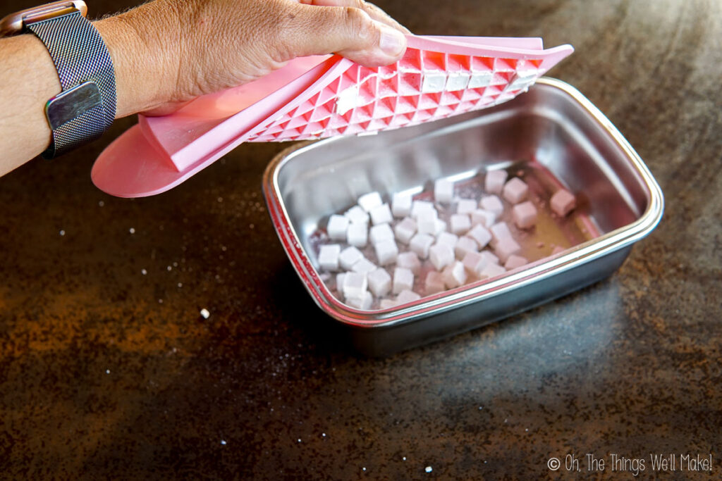 unmolding toothpaste tablets into a steel container. 