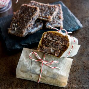 pemmican bars wrapped in paper in front of a tray with more pemmican bars