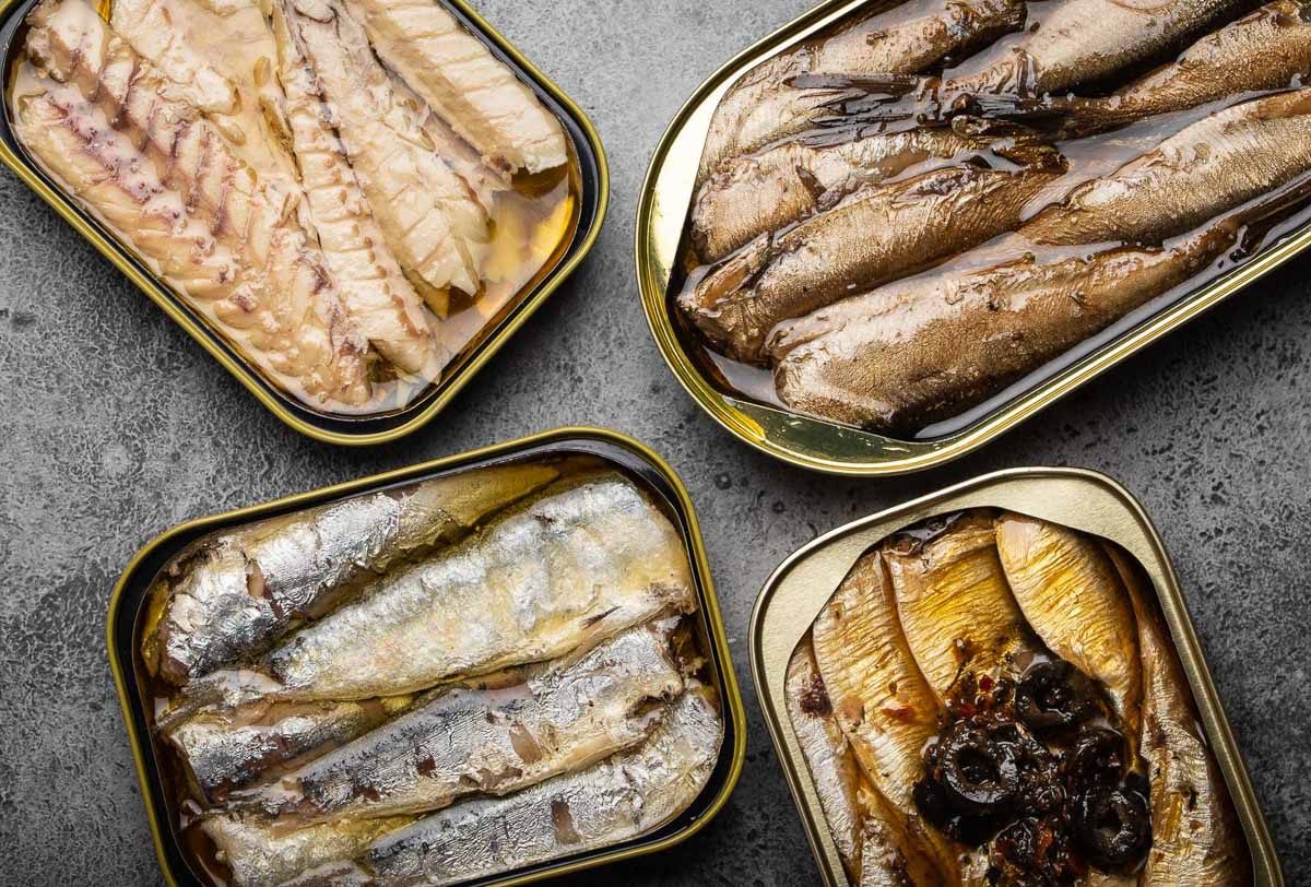 overhead view of 4 open tins of canned fish