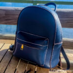 A blue leather backpack on a wooden table