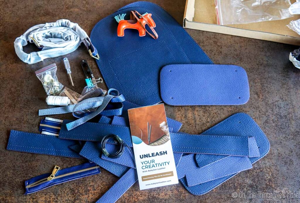Pieces of leather from a leather kit on a brown counter.