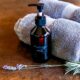 Bottle of homemade massage oil with towels and lavender.