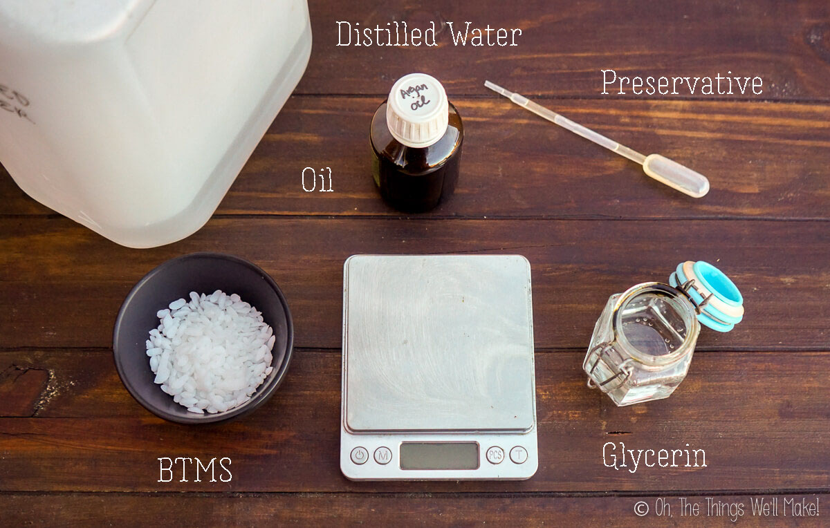 Top view of ingredients for a DIY hair conditioner: distilled water, oil, preservative, BTMS pellets, glycerin, and a digital scale.